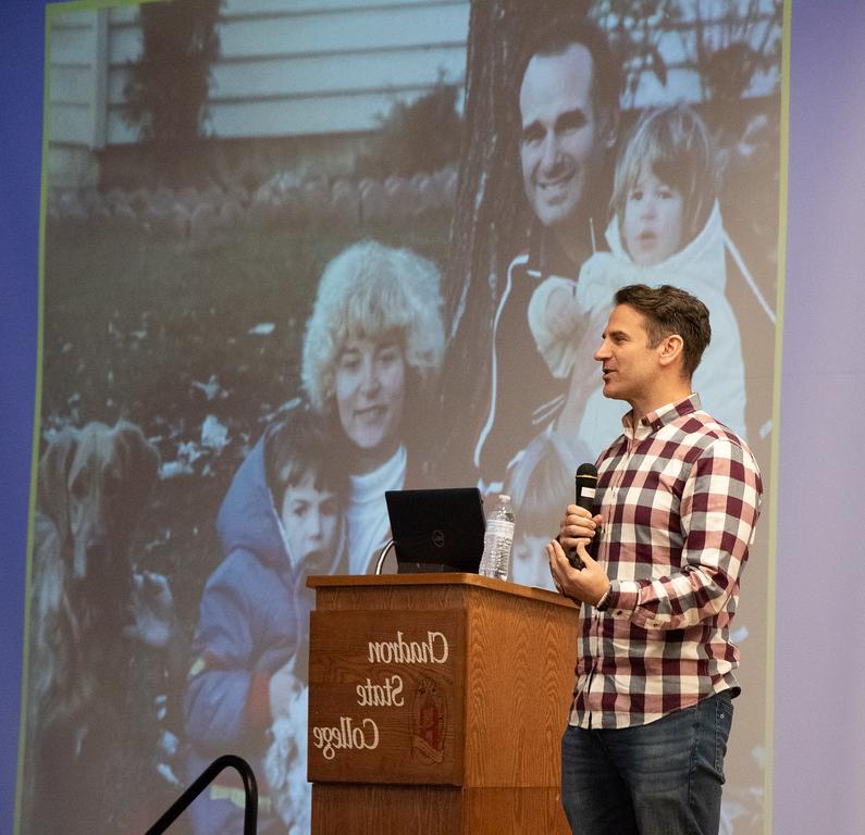 Male speaker in front of slide presentation